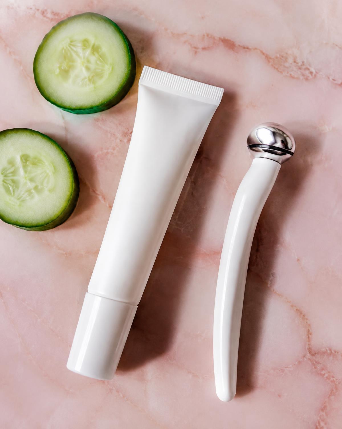 Eye cream tube, cooling roller and cucumber slices