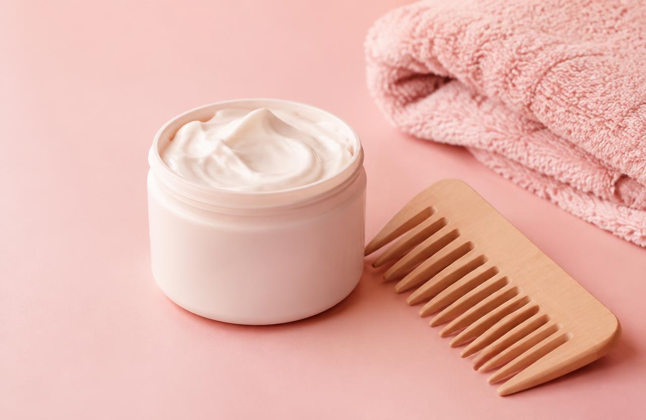 Hair mask jar, wooden comb and pink towel